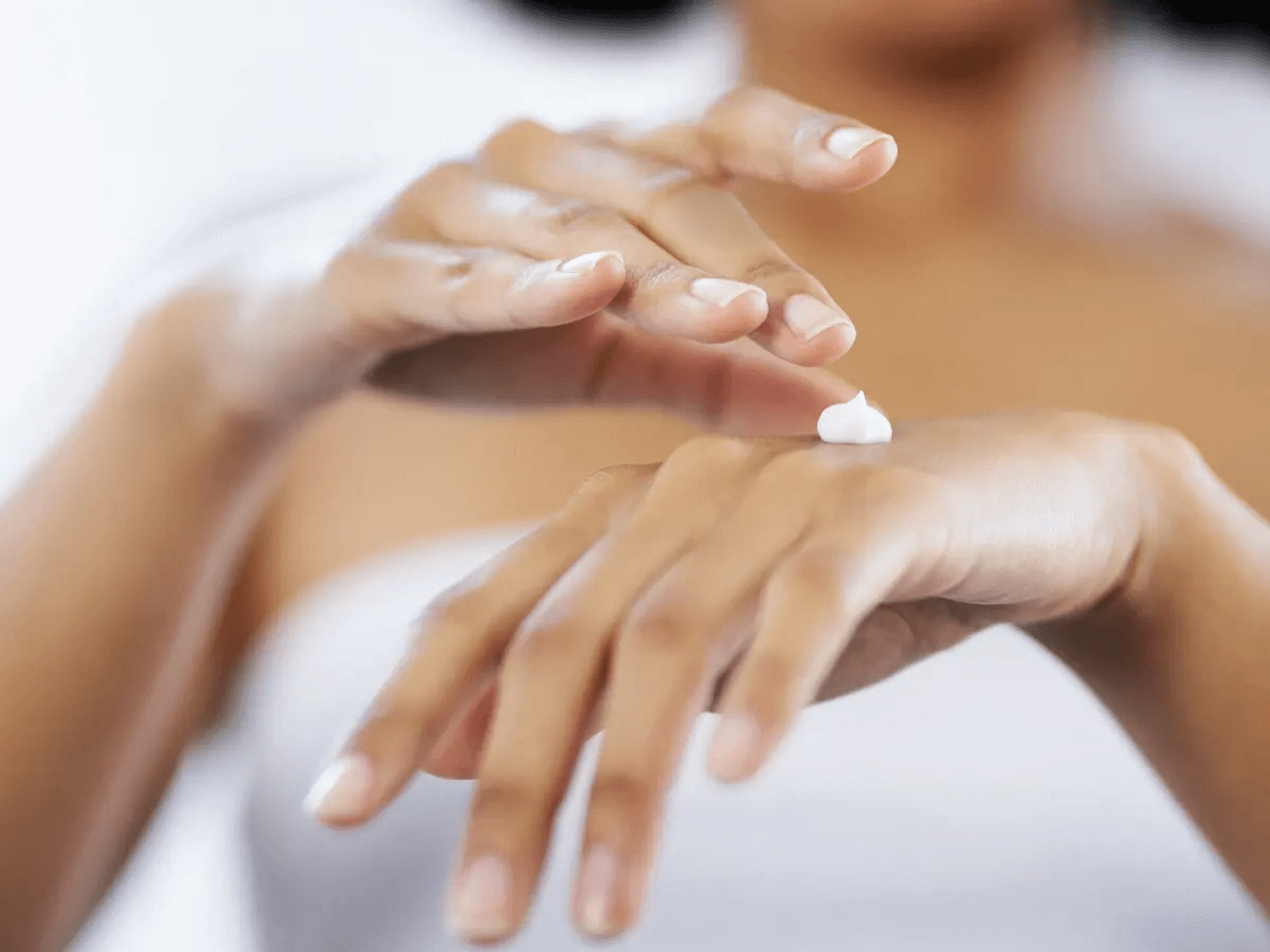 person's hands about to rub in hand cream on the back of their hand