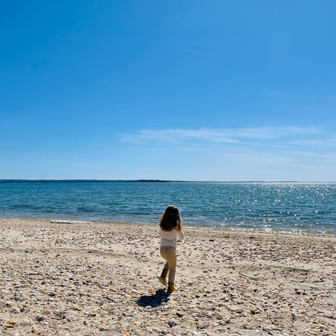 child throws stones on Shelter Island beach