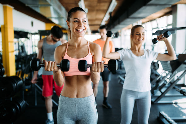 A woman lifting weights and enjoying the benefits of proteolytic enzymes