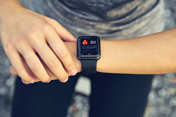 A person checking their smartwatch to check some of the benefits of proteolytic enzymes