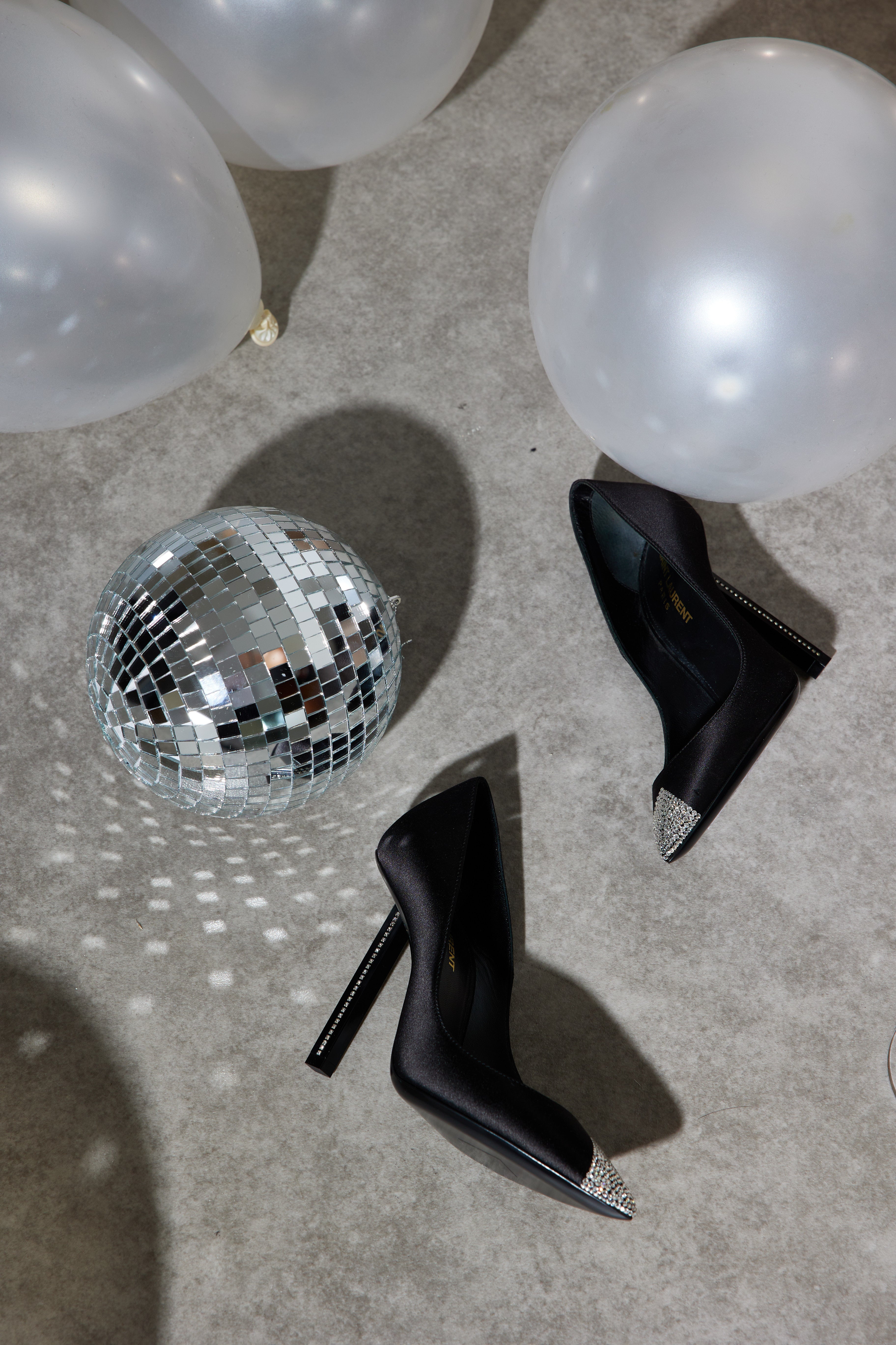 Saint Lauren Black Tower 110 heels aesthetically laying on floor with disco ball and white ballons