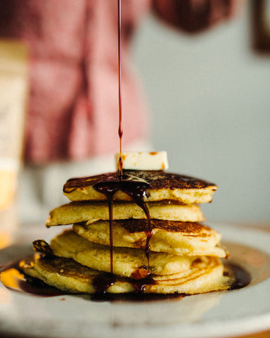 A stack of pancakes with syrup being poured over them for the holiday 12 days of Christmas promotion