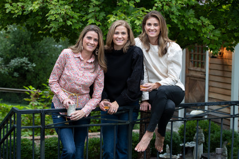 The sister founders behind Pappy & Co.: Louise, Carrie, and Chenault, each holding a glass of fine bourbon
