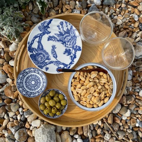 FERIDIES Peanuts on a wooden platter with olives and blue ceramic plates