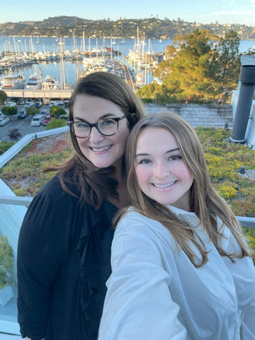 Jill Santa-Lucia and Ella of Ella's Popcorn posed over a marina with boats in the background