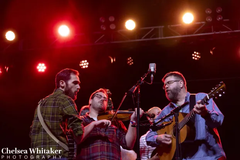 Round Creek performs under red stage lights.