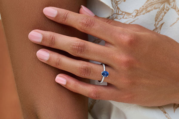 Oval blue sapphire with hidden diamond halo and pavé band engagement ring