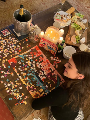 Woman drinking wine whilst doing a cool jigsaw puzzle