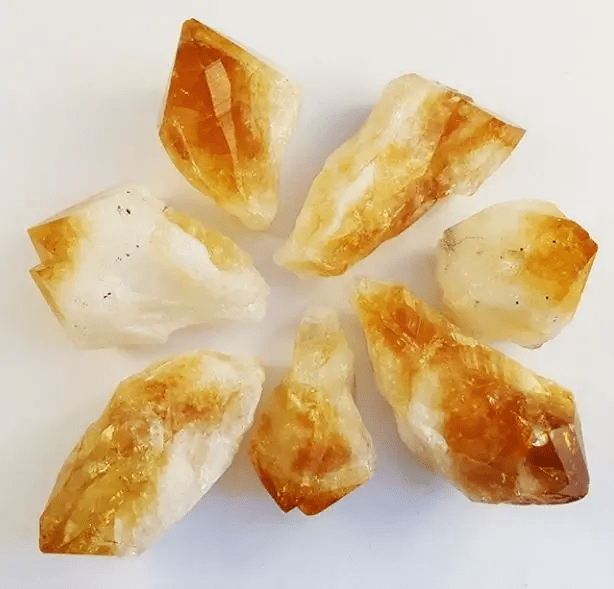 pieces of raw citrine crystals on a white background top flat lay view