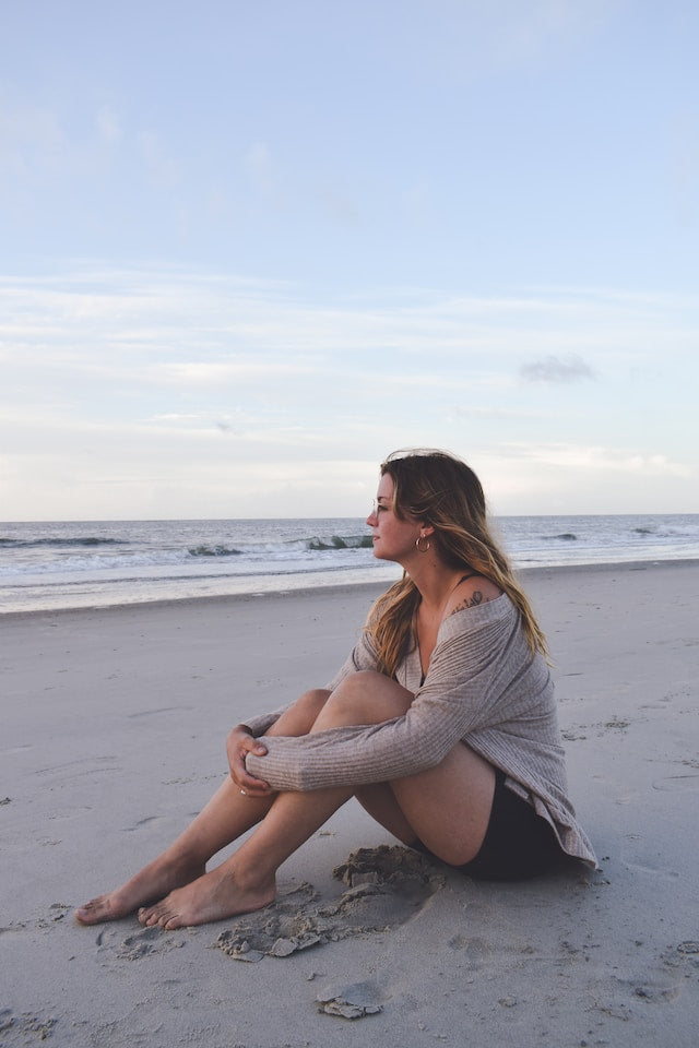 a woman sitting on the beach