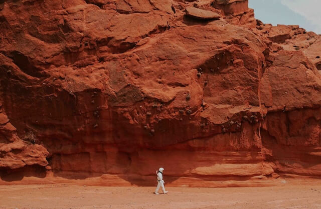 person walking near brown rocks