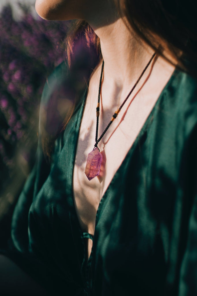 a woman wearing a crystal point necklace