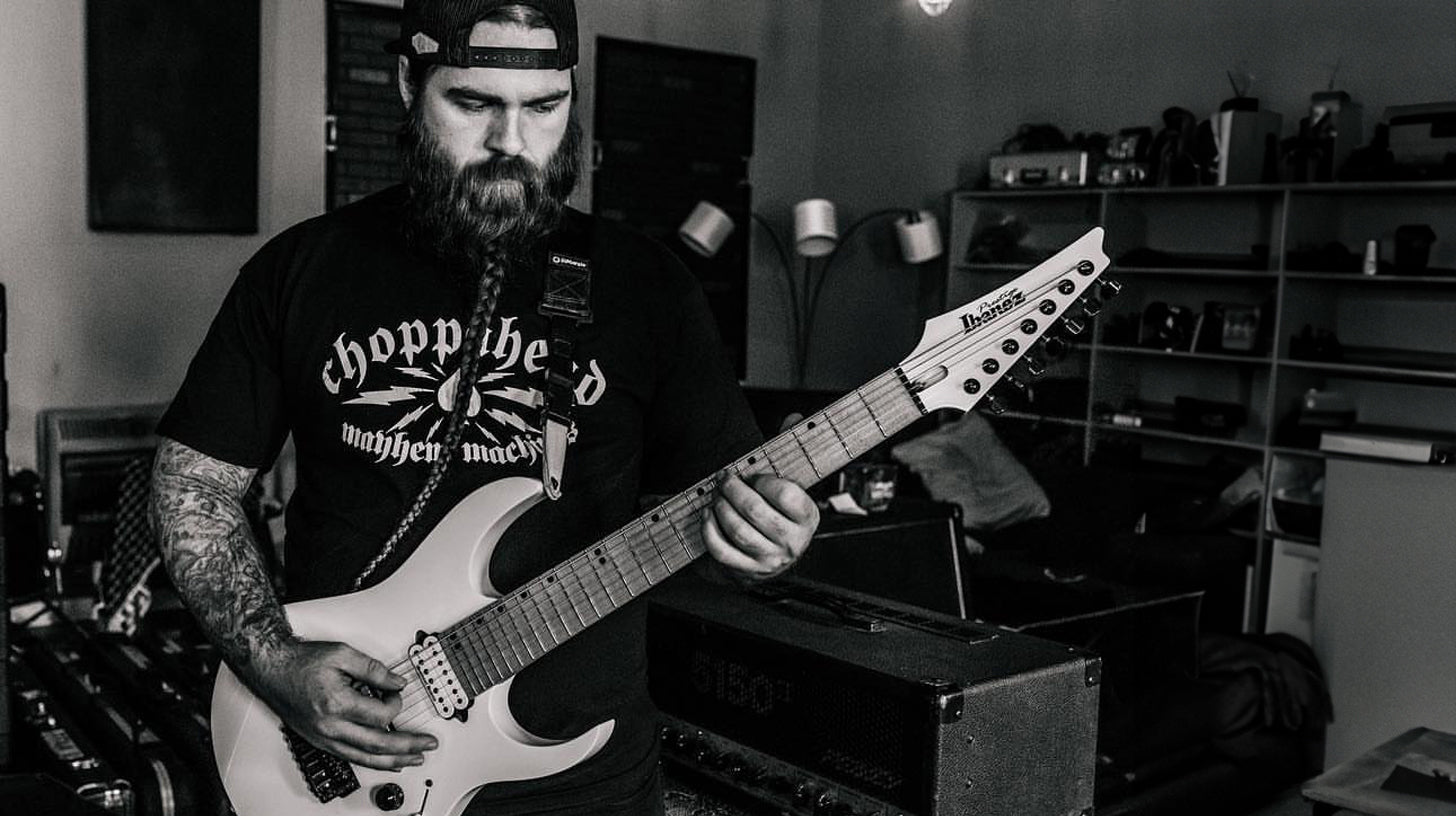 man playing guitar with viking beard braid