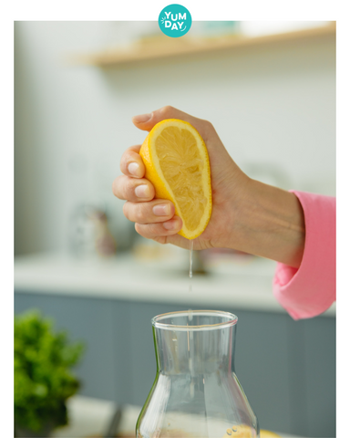 Hand squeezing lemon juice into a glass container