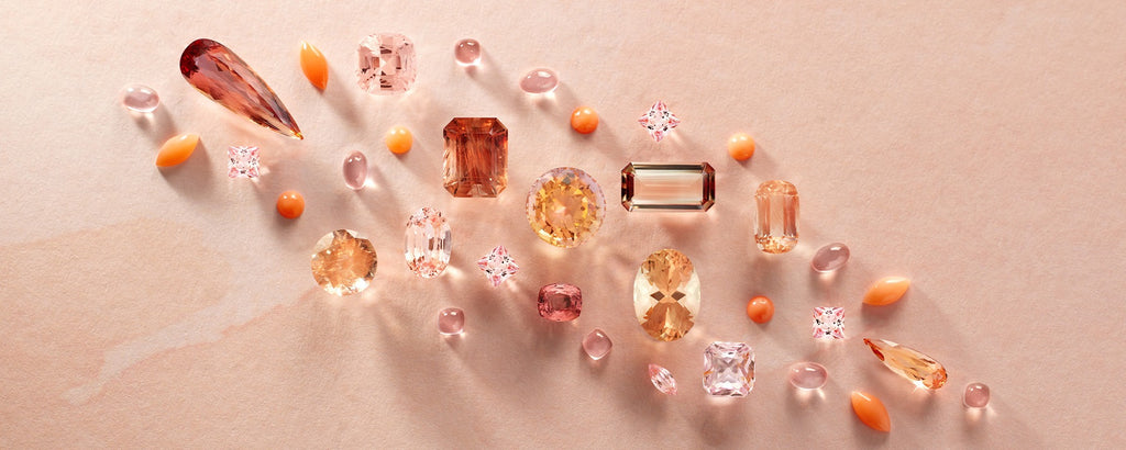 A group of gemstones in an array of shapes and sizes, placed diagonally. The gems are all in peach to pink shades.