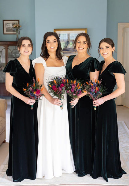 bride and bridesmaid in dark green dress holding preserved flowers bouquets