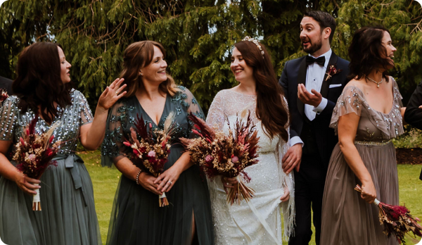 Bride at a wedding holding a dried flower bouquet next to her bridesmaids.