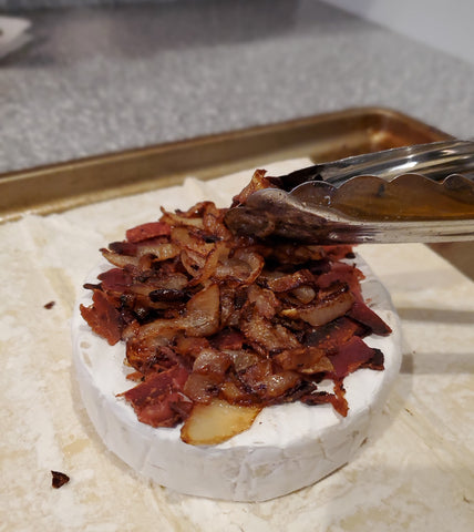 cooked bacon on top of sautéed onions