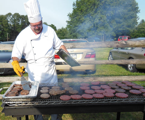 Stoltzfus Meats chef cooking burgers on a large grill