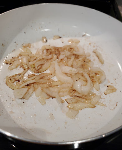 onions sautéing in a frying pan