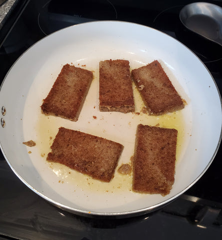 cooking scrapple slices in a frying pan