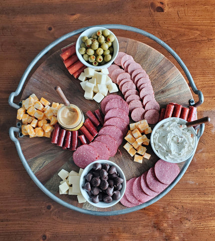 various meats, cheeses, olives, spreads, and wilbur buds on a charcuterie board