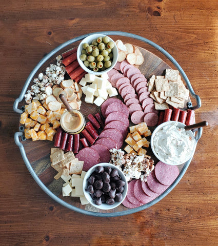 various crackers, meats, cheeses, olives, spreads, and wilbur buds on a charcuterie board