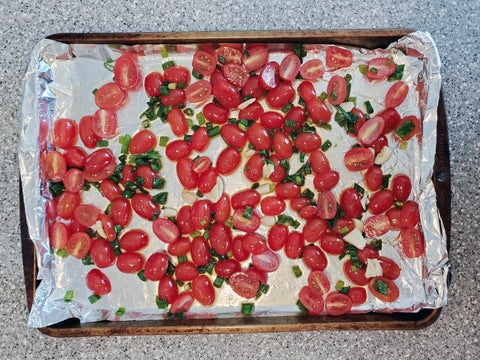 tomatoes, green onions, garlic, olive oil, salt, and sugar on a baking sheet