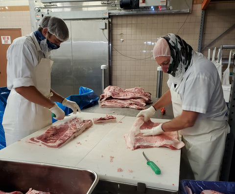 Two of our expert meat cutters, Jason and Norm, checking each slab and trimming off any excess fat.