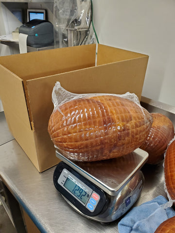 weighing fully cooled and packaged hams
