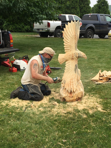 local artisan carving a wooden eagle out of a stump