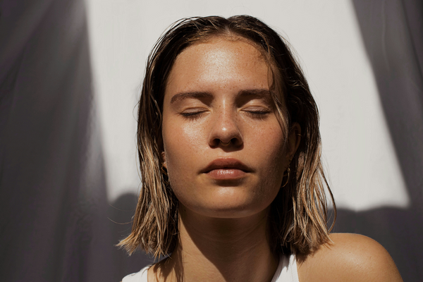 A woman with her eyes closed. Oily hair