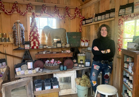 Mrs. M inside the Sugar Shack located at 492 Beechwood Street in Cohasset, Massachusetts surrounded by a large selection of our gourmet bars, brownies, breads, chocolates, caramels, cookies, cakes, coffees, teas, maple syrups, hot chocolates, gift boxes, and so much more