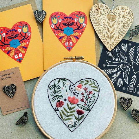 Image shows a collection of cards, pins and embroidery which are heart-shaped