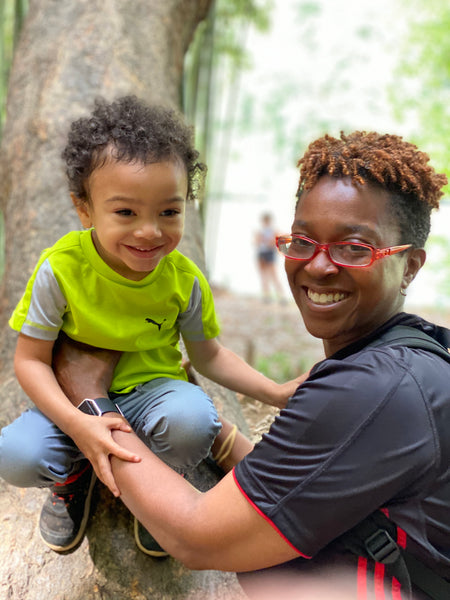 Black woman and son hike happily