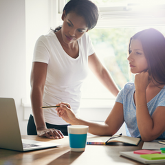 Woman with FAM instructor, clarifying fertility awareness charts on a computer