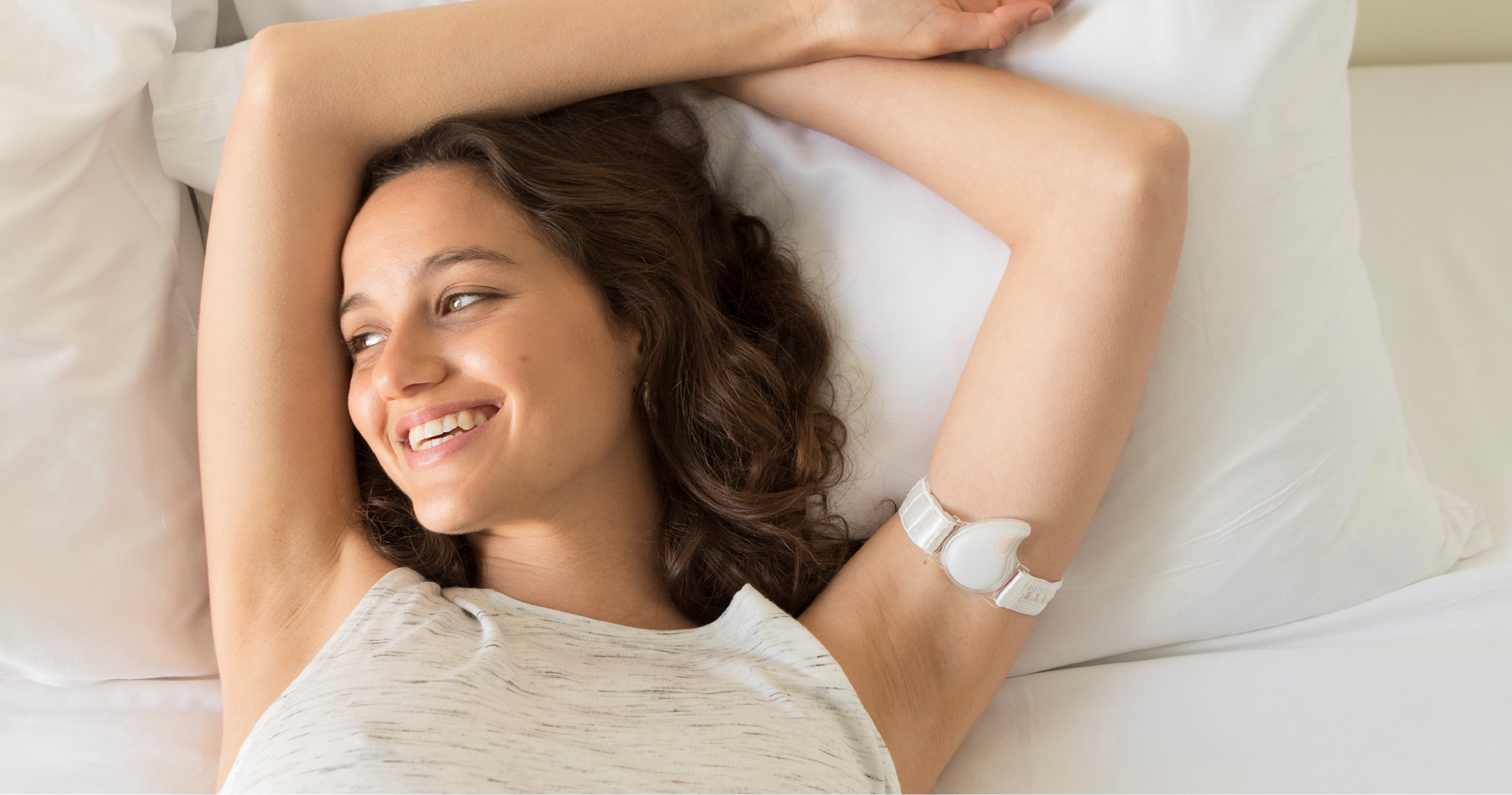 woman lying in bed wearing a Tempdrop