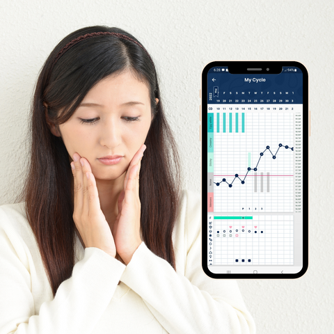 An anxious woman, next to her is her fertility chart showing she has ovulated