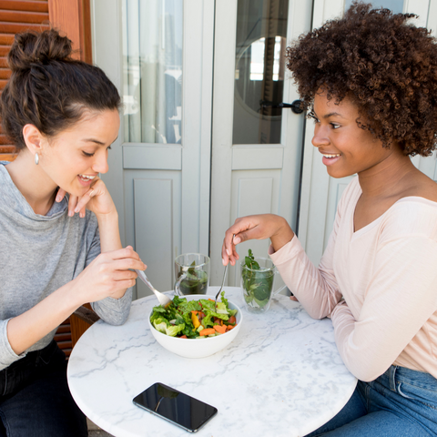 Two women eating a healthy lunch together.