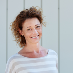 Woman in her 40s smiling at the camera, happy with life