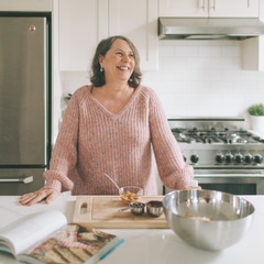 menopausal woman smiling and cooking in her kitchen