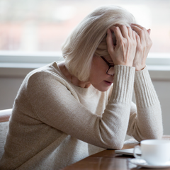 Middle aged woman leaning her heads on her hand in frustration