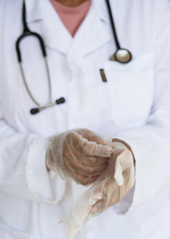 doctor putting gloves on for female health check