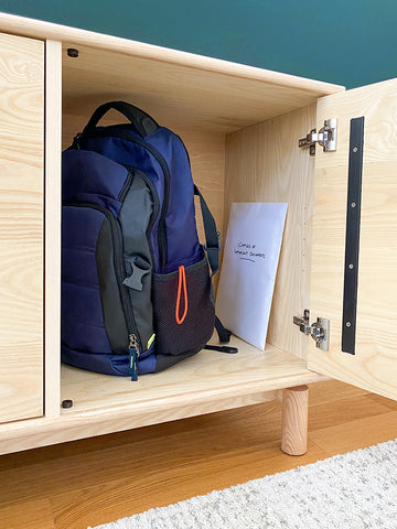 Forti Goods Florence wood cabinet showing a disaster preparedness backpack on the shelf of a lockable cabinet.