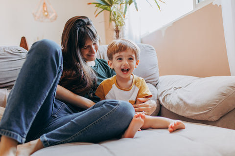 Mom and toddler son sitting on sofa having a sweet conversation