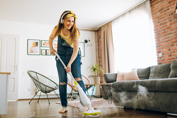 Woman cleaning house with headphones