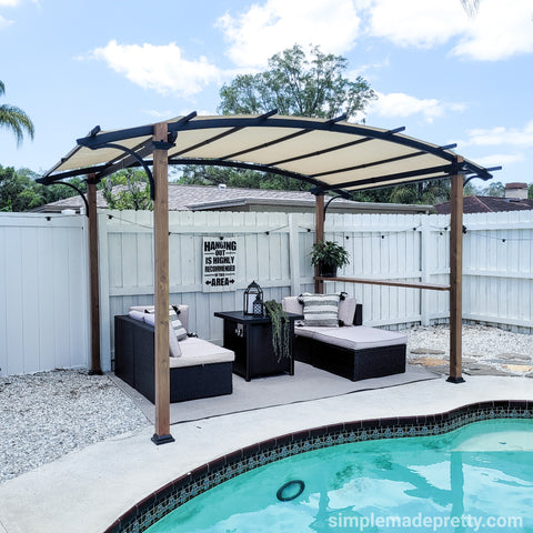 Sunjoy 8.5 ft. x 13 ft. Steel Arched Pergola with Natural Wood Looking Finish and Tan Shade and Shelf