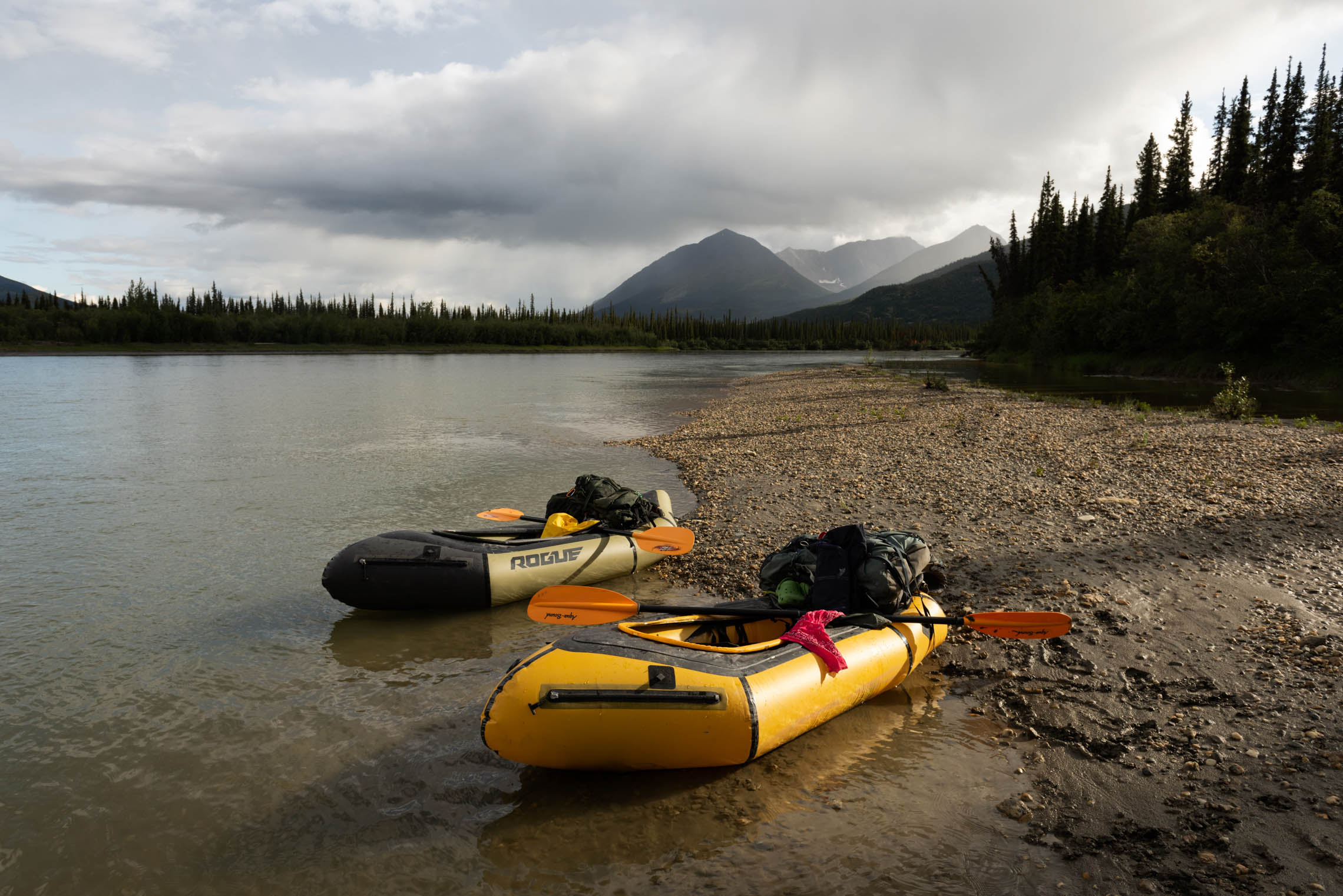 Kokopelli packrafts docked next to a lake with mountains and trees