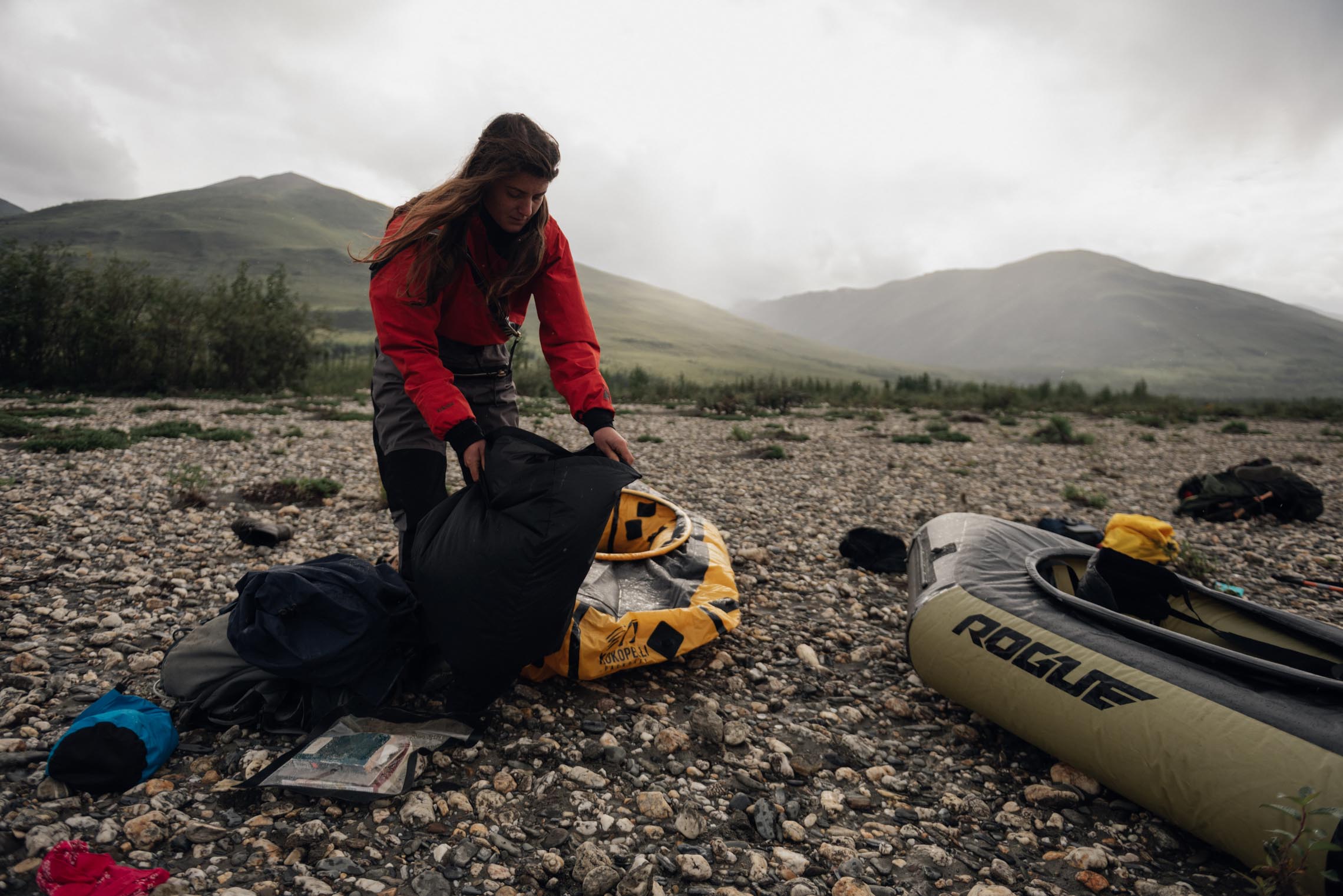 Woman packing a Kokopelli packraft in the gates of the arctic