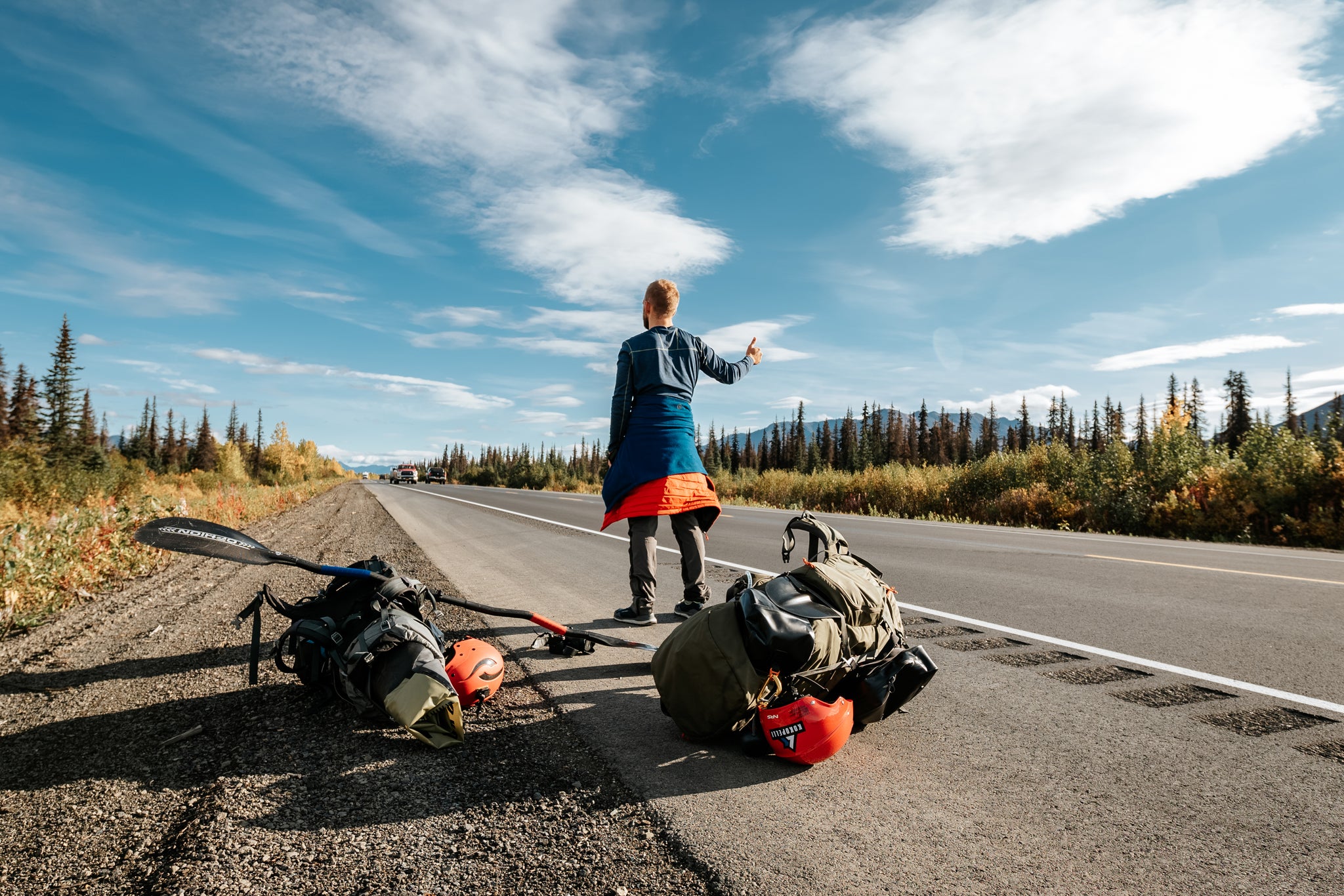 Nick Coulter hitch hiking for a shuttle lap with packrafting gear